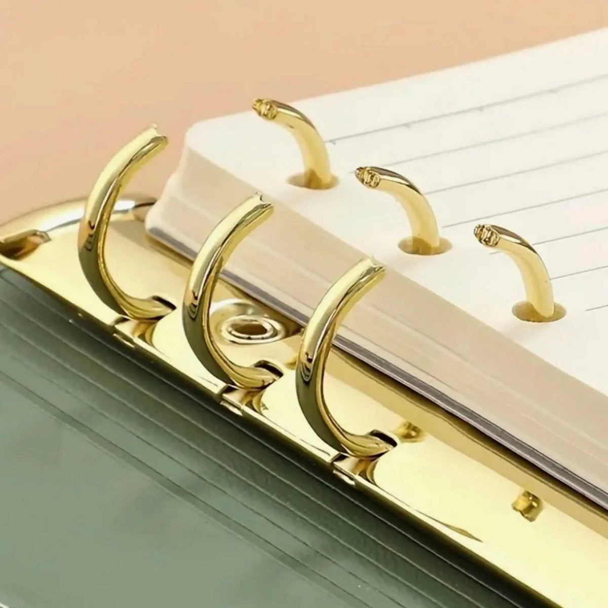 Notizbuch Binder mit olivgrünem Einband, cremefarbenen Blättern und glänzend goldener Metall-Ringmechanik.