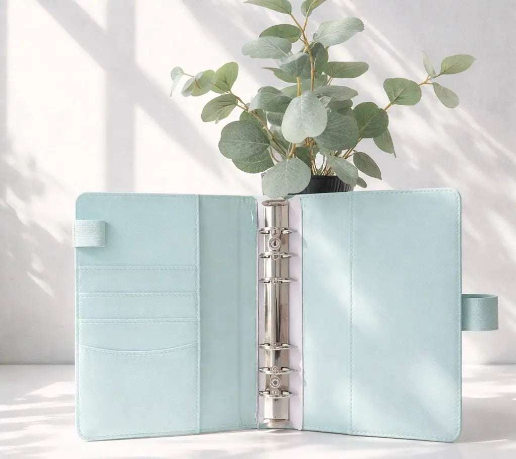 Budget Binder Set im A6-Format, hellblauer Binder mit glatter Oberfläche, silberner Ringmechanik und Kartenfächern innen.