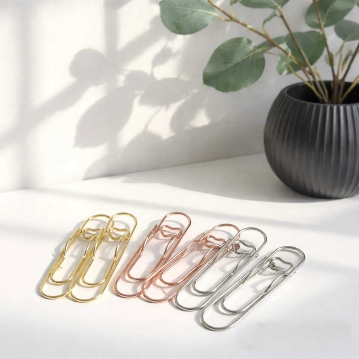 Buchklammer Herz aus Metall in Gold-, Roségold- und Silberfarben, mit schlichtem, länglichem Design.